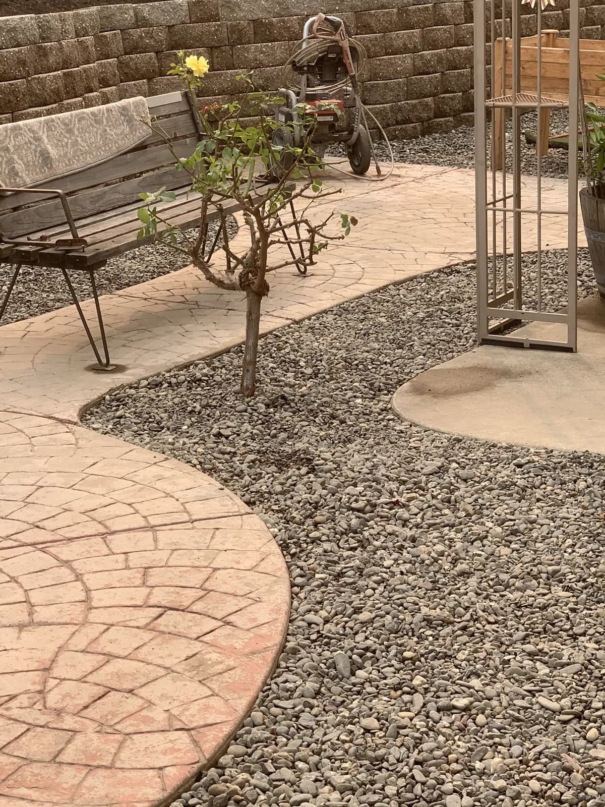 Stamped concrete walkway curving through a gravel garden