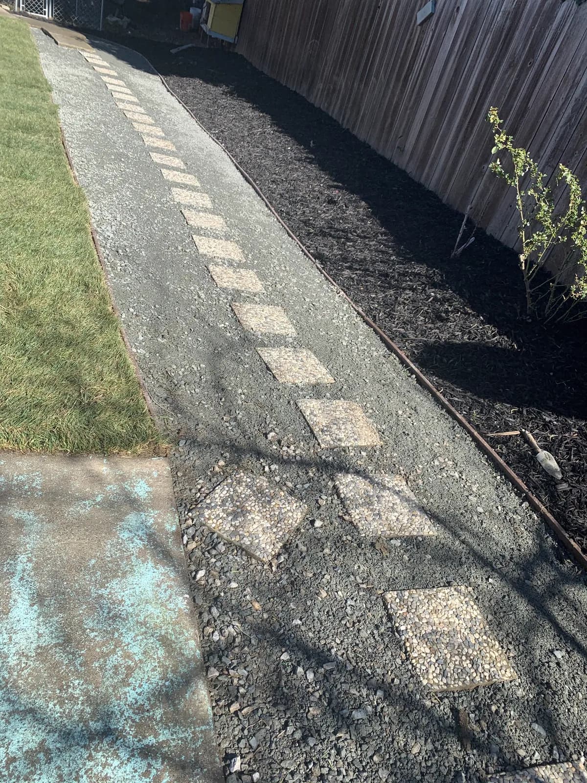 Completed drain run finished with dark gravel and a paver edge